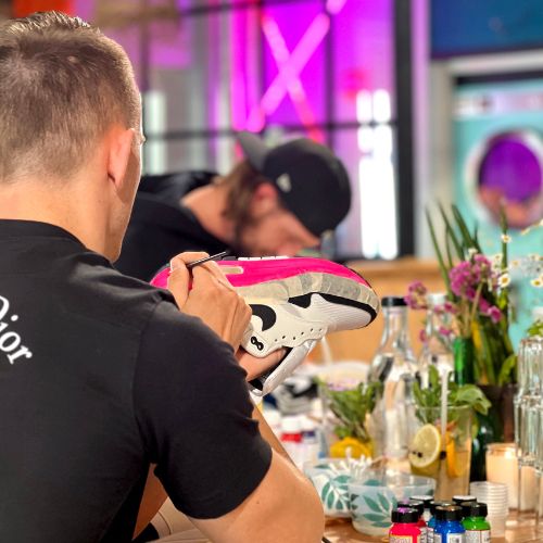 Vriendengroep tijdens een creatieve workshop sneaker customization als groepsactiviteit in Breda.