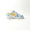 Achteraanzicht van custom Nike kinderschoen met blauwe bliksem details en witte veters.